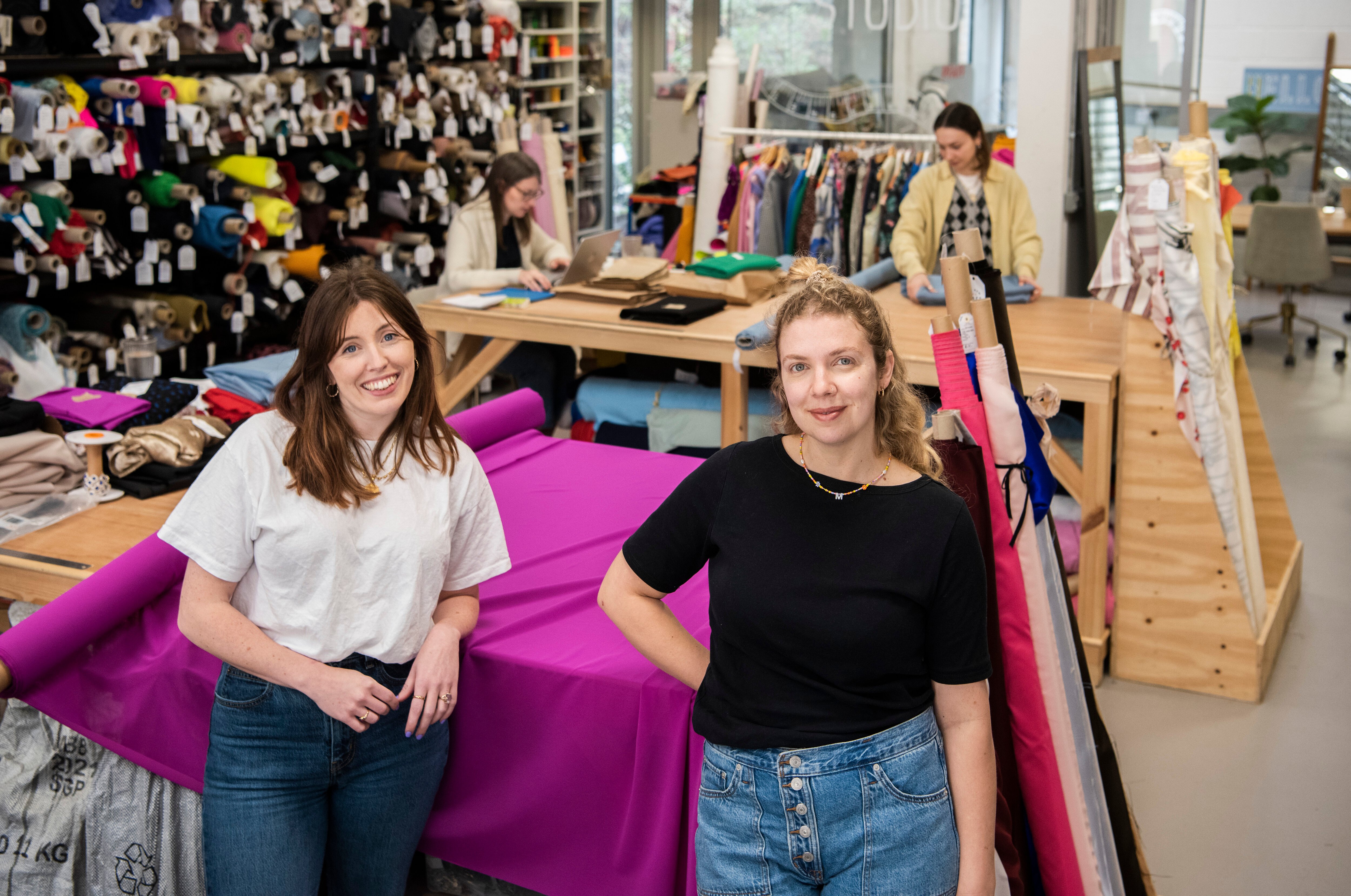 Hannah and Rosie in front of fabric bolts in the New Craft House